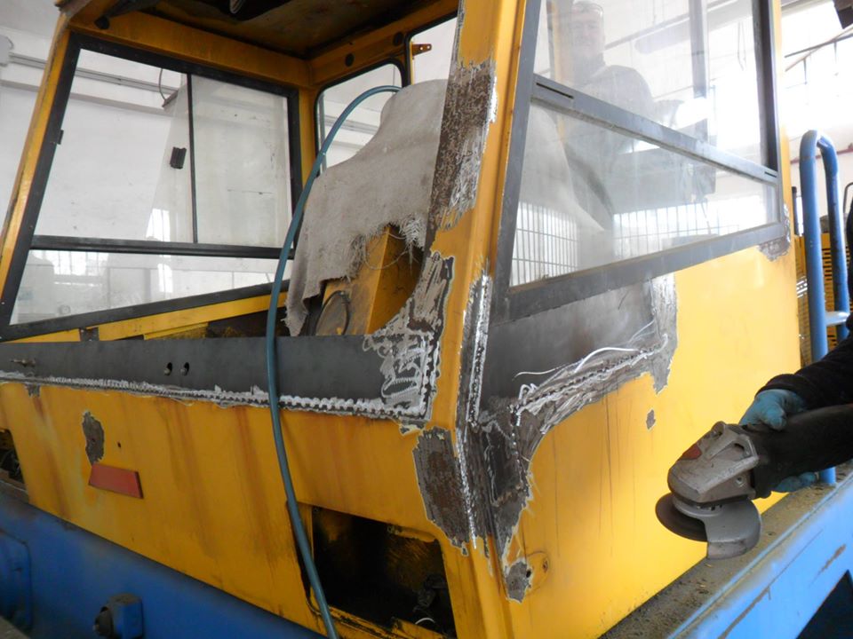 Lavorazione sulla cabina di un mezzo industriale giallo
